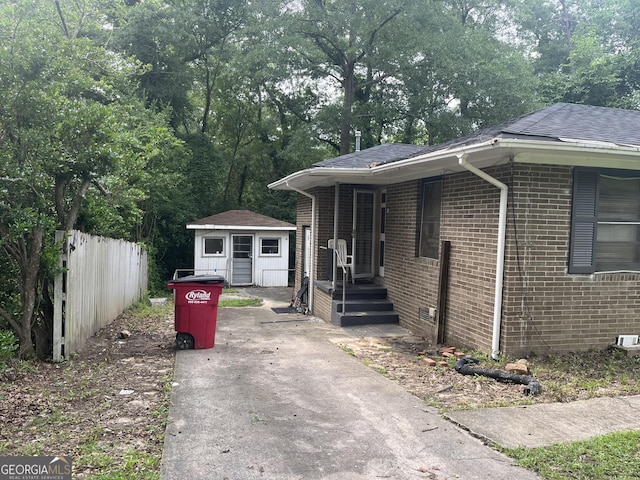 2526 Kensington Rd, Macon, GA 31211 - view of front of house with brick siding, an outdoor structure, driveway, and a shingled roof
