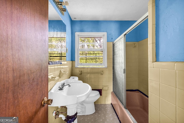 2531 Hood Ave NW, Atlanta, GA 30318 - full bath with tile patterned flooring, toilet, combined bath / shower with glass door, and tile walls