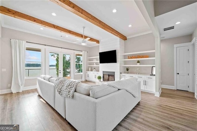 103 Jackson Ridge Dr, Monticello, GA 31064 - living area with baseboards, a large fireplace, light wood finished floors, beamed ceiling, and ceiling fan