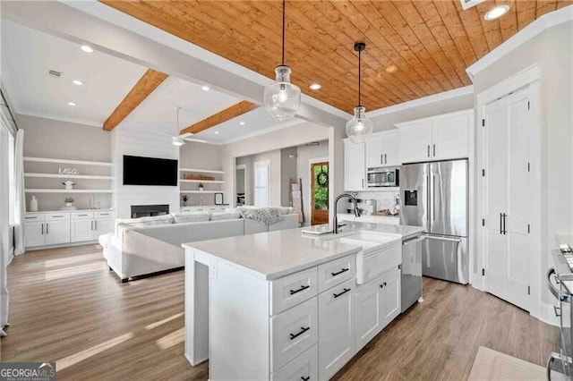 103 Jackson Ridge Dr, Monticello, GA 31064 - kitchen featuring stainless steel appliances, white cabinets, light countertops, hanging light fixtures, and wood finished floors