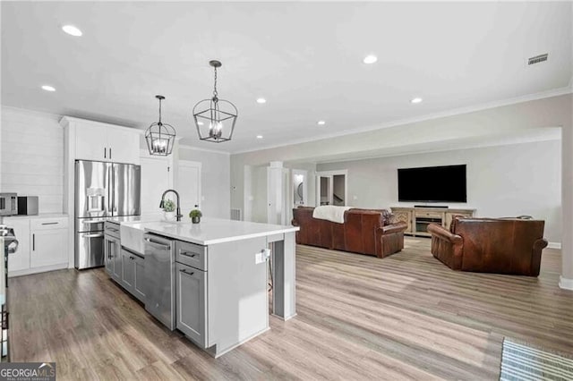 103 Jackson Ridge Dr, Monticello, GA 31064 - kitchen with stainless steel appliances, ornamental molding, light countertops, gray cabinets, and a chandelier
