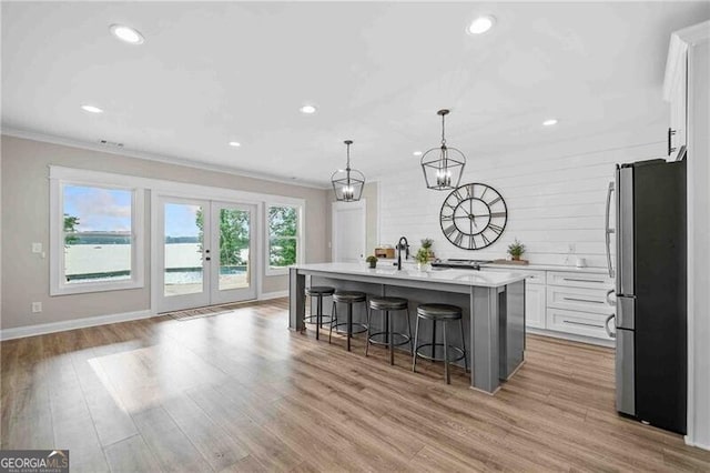 103 Jackson Ridge Dr, Monticello, GA 31064 - kitchen featuring freestanding refrigerator, crown molding, a kitchen bar, light countertops, and white cabinets