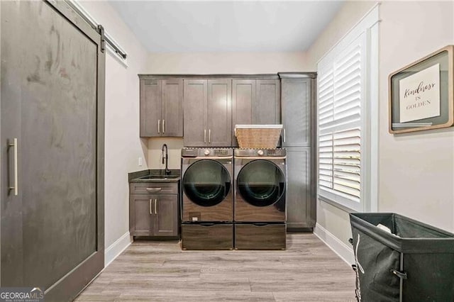 103 Jackson Ridge Dr, Monticello, GA 31064 - washroom featuring cabinet space, washer and clothes dryer, a barn door, and baseboards