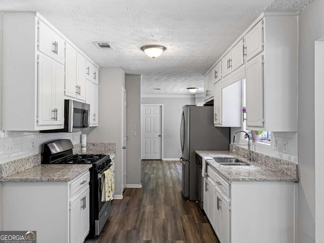 30 Court S, Ellenwood, GA 30294 - kitchen featuring appliances with stainless steel finishes, a sink, white cabinets, decorative backsplash, and a textured ceiling