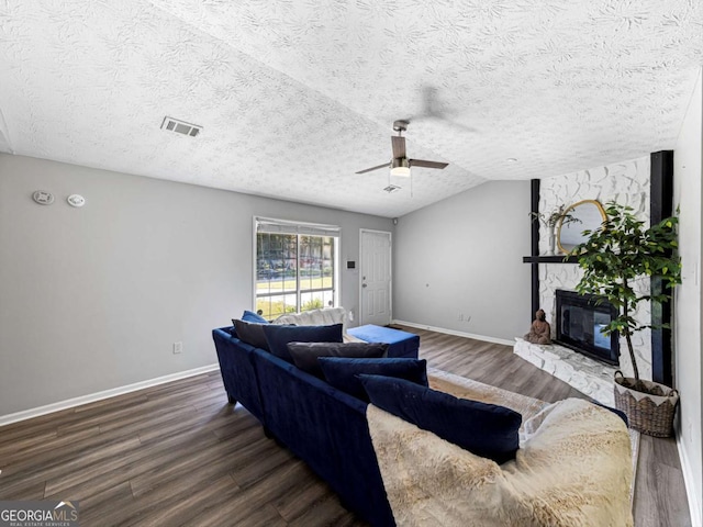 30 Court S, Ellenwood, GA 30294 - living room featuring dark wood-type flooring, baseboards, a ceiling fan, a stone fireplace, and a textured ceiling