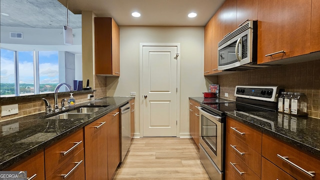 3300 Windy Ridge Pkwy SE, Atlanta, GA 30339 - kitchen with stainless steel appliances, a sink, light wood-style floors, brown cabinetry, and recessed lighting