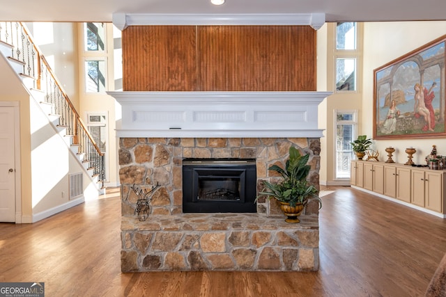 33 T J Mote Rd, Dahlonega, GA 30533 - living room featuring a stone fireplace, baseboards, stairway, wood finished floors, and a towering ceiling
