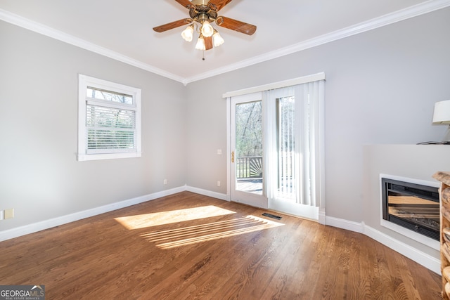 33 T J Mote Rd, Dahlonega, GA 30533 - unfurnished living room with ornamental molding, baseboards, wood finished floors, a glass covered fireplace, and a ceiling fan