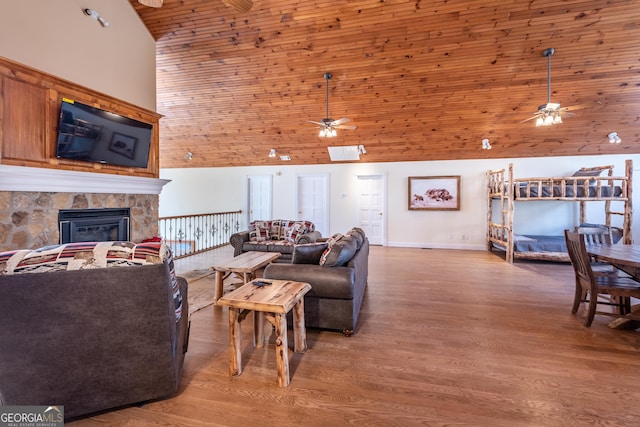 33 T J Mote Rd, Dahlonega, GA 30533 - living room featuring a ceiling fan, high vaulted ceiling, a stone fireplace, wood finished floors, and baseboards