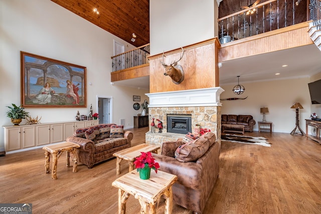 33 T J Mote Rd, Dahlonega, GA 30533 - living room with a high ceiling, light wood finished floors, a stone fireplace, crown molding, and recessed lighting