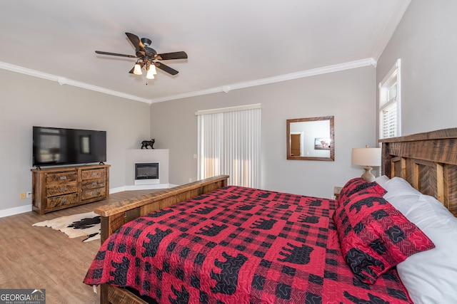 33 T J Mote Rd, Dahlonega, GA 30533 - bedroom featuring wood finished floors, ornamental molding, a glass covered fireplace, baseboards, and a ceiling fan