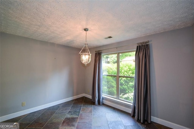 4766 Jamerson Forest Cir, Marietta, GA 30066 - unfurnished room with a chandelier, stone tile flooring, and a textured ceiling