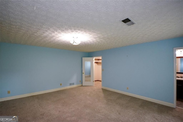 4766 Jamerson Forest Cir, Marietta, GA 30066 - unfurnished bedroom featuring carpet floors, a textured ceiling, ensuite bath, and a spacious closet