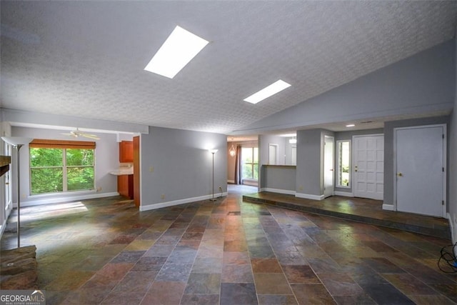4766 Jamerson Forest Cir, Marietta, GA 30066 - unfurnished living room with plenty of natural light, dark stone finish floors, a textured ceiling, lofted ceiling, and ceiling fan