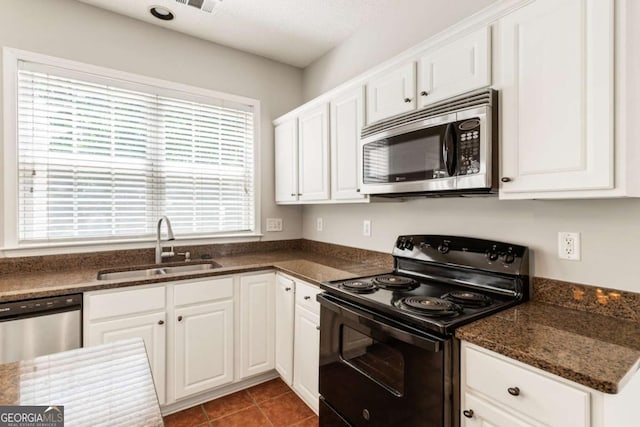 144 Nocatee Trl, Woodstock, GA 30188 - kitchen with stainless steel appliances, white cabinetry, dark stone counters, and tile patterned flooring