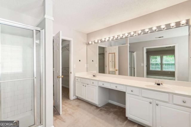 144 Nocatee Trl, Woodstock, GA 30188 - full bath with a stall shower, double vanity, a textured ceiling, and a walk in closet