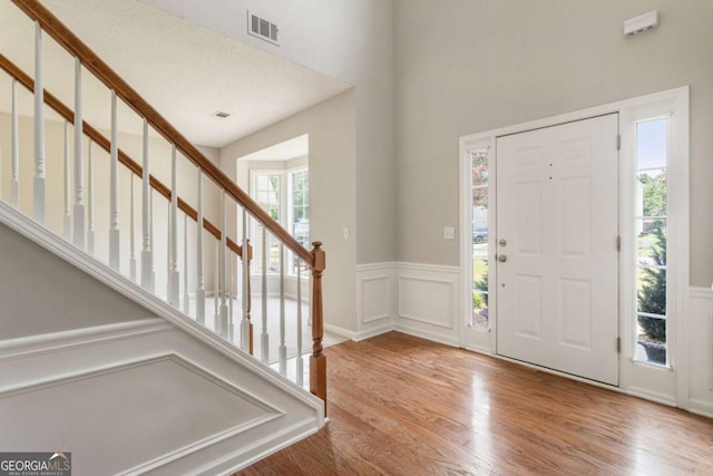 144 Nocatee Trl, Woodstock, GA 30188 - foyer entrance featuring wood finished floors, stairway, a wainscoted wall, and a decorative wall