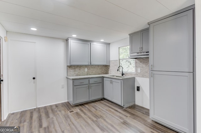 2526 Bald Eagle Trl, Gainesville, GA 30507 - kitchen featuring gray cabinets, a sink, under cabinet range hood, tasteful backsplash, and recessed lighting