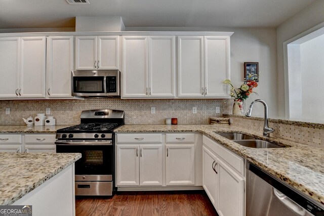 5016 Garrett Ct, Alpharetta, GA 30005 - kitchen with stainless steel appliances, a sink, white cabinetry, wood finished floors, and light stone countertops