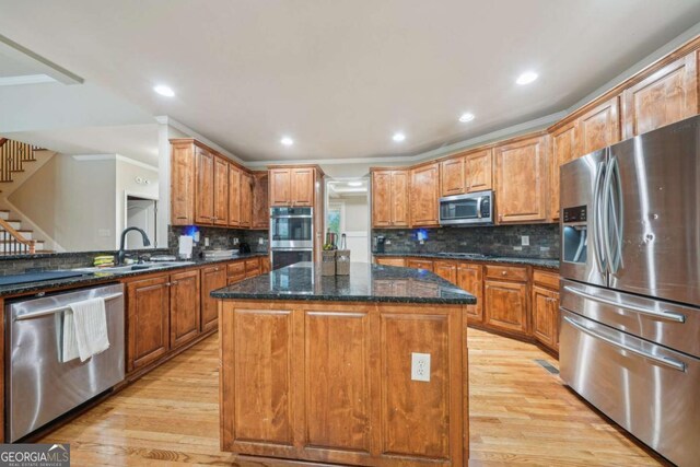 1979 Alcovy Shoals Blf, Lawrenceville, GA 30045 - kitchen featuring stainless steel appliances, a center island, light wood-style flooring, tasteful backsplash, and dark stone counters