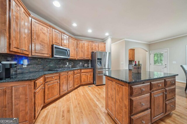 1979 Alcovy Shoals Blf, Lawrenceville, GA 30045 - kitchen featuring stainless steel appliances, arched walkways, light wood-type flooring, ornamental molding, and tasteful backsplash