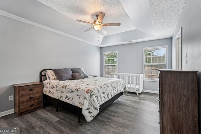 1415 Langdon Park Ct, Winder, GA 30680 - bedroom featuring a raised ceiling, a textured ceiling, dark wood finished floors, and a ceiling fan