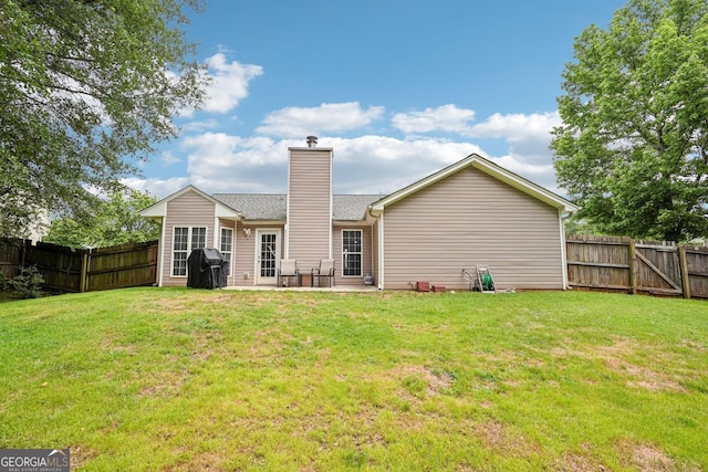1415 Langdon Park Ct, Winder, GA 30680 - back of property with a chimney, a fenced backyard, and a patio