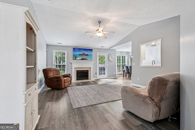 1415 Langdon Park Ct, Winder, GA 30680 - living area featuring wood finished floors, a ceiling fan, a fireplace, a textured ceiling, and vaulted ceiling