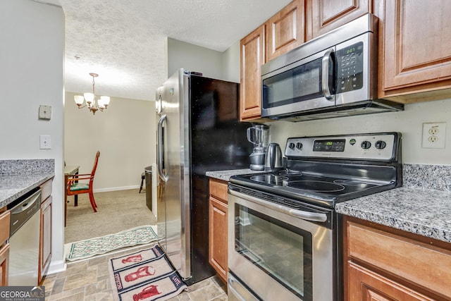 12303 Waldrop Pl, Decatur, GA 30034 - kitchen with stainless steel appliances, a chandelier, baseboards, brown cabinets, and a textured ceiling