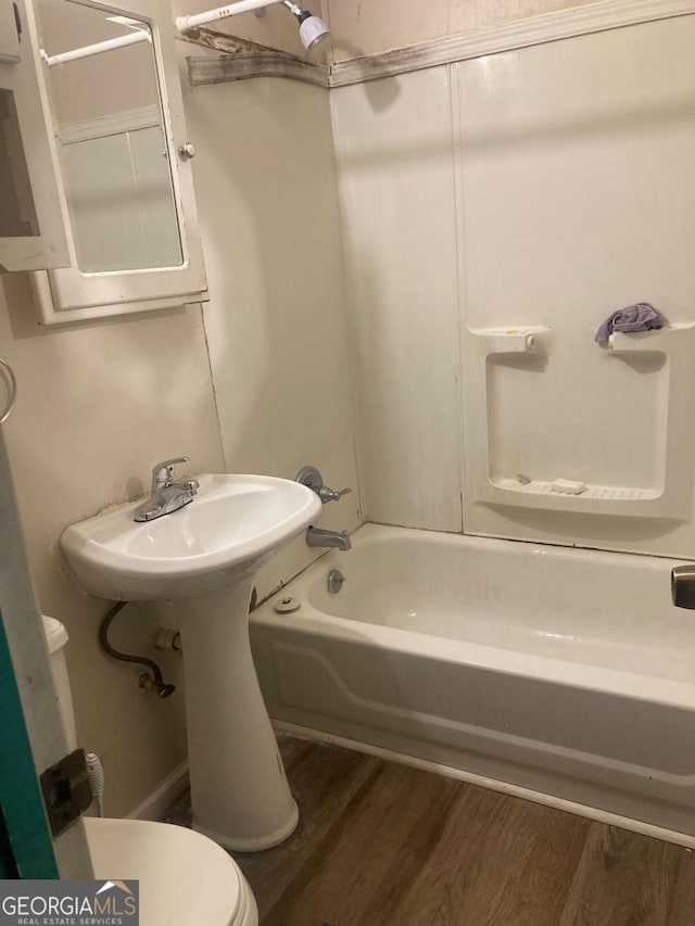 2722 Alden St, Macon, GA 31206 - bathroom featuring wood finished floors, toilet, tub / shower combination, and a sink