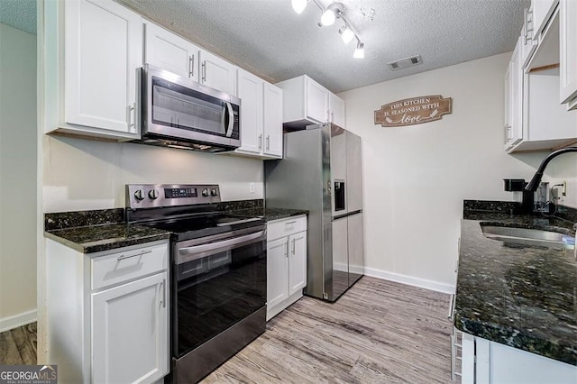907 Magnolia Ext, Guyton, GA 31312 - kitchen featuring stainless steel appliances, a sink, a textured ceiling, light wood-style flooring, and white cabinets