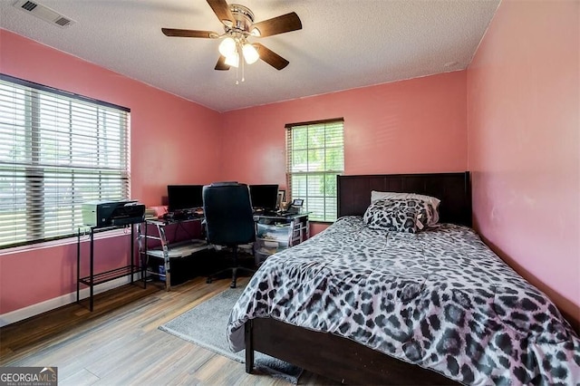 907 Magnolia Ext, Guyton, GA 31312 - bedroom featuring wood finished floors, a textured ceiling, a ceiling fan, and an office area