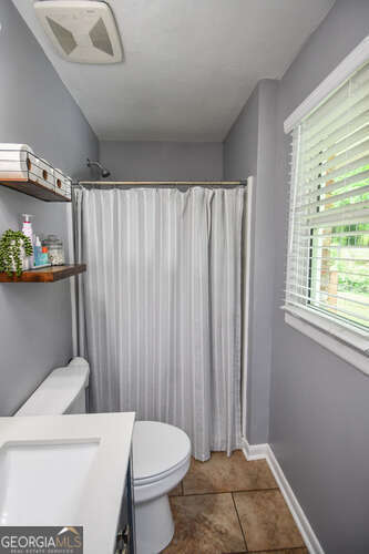 120 Chambers Ave, Cornelia, GA 30531 - bathroom featuring toilet, tile patterned flooring, vanity, and curtained shower
