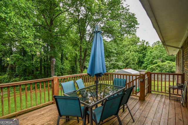 120 Chambers Ave, Cornelia, GA 30531 - wooden deck featuring outdoor dining area, a lawn, and a wooded view