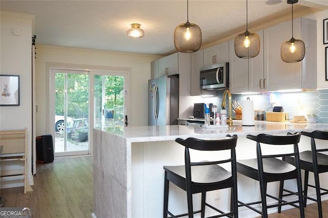 5419 Lake Dr, Douglasville, GA 30135 - kitchen featuring stainless steel appliances, crown molding, a sink, tasteful backsplash, and a kitchen bar