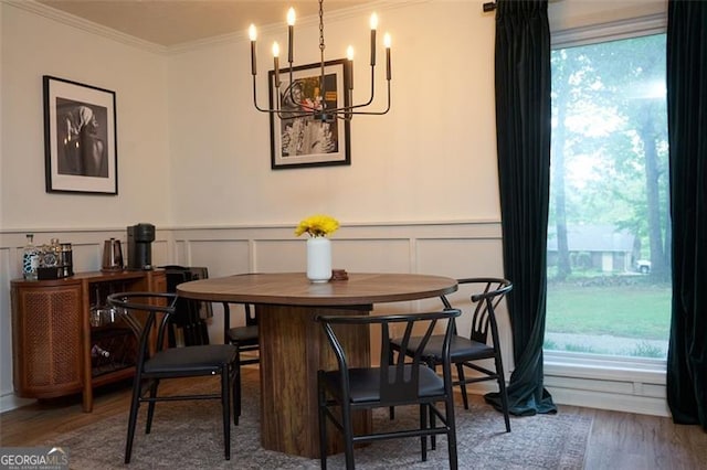 5419 Lake Dr, Douglasville, GA 30135 - dining room featuring a chandelier, wood finished floors, a decorative wall, ornamental molding, and wainscoting
