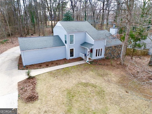 5419 Lake Dr, Douglasville, GA 30135 - traditional-style home featuring a chimney, concrete driveway, a shingled roof, and view of wooded area