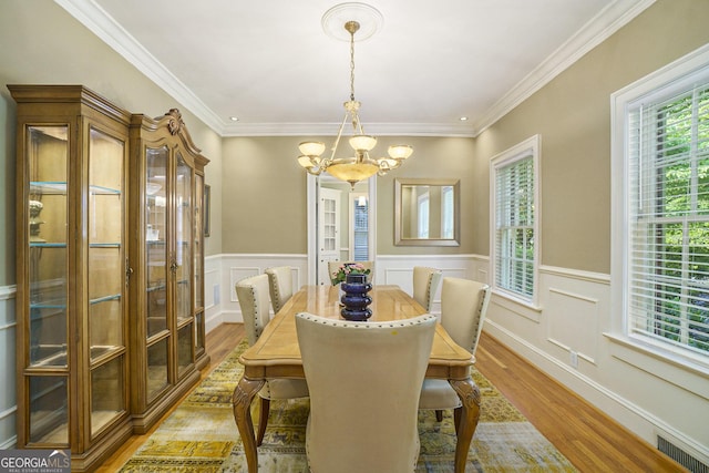 1821 N Rock Springs Rd NE, Atlanta, GA 30324 - dining area featuring a chandelier, light wood finished floors, crown molding, wainscoting, and a decorative wall