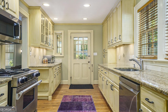 1821 N Rock Springs Rd NE, Atlanta, GA 30324 - kitchen with stainless steel appliances, cream cabinetry, light wood-type flooring, glass insert cabinets, and light stone countertops