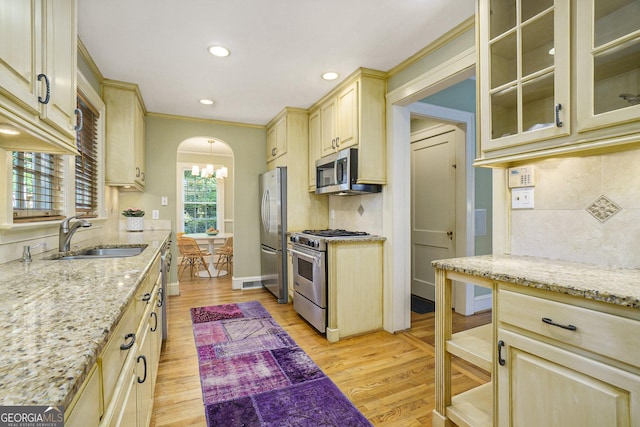 1821 N Rock Springs Rd NE, Atlanta, GA 30324 - kitchen with appliances with stainless steel finishes, arched walkways, light wood-style floors, light stone countertops, and recessed lighting
