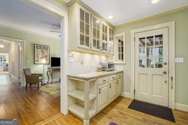 1821 N Rock Springs Rd NE, Atlanta, GA 30324 - kitchen with cream cabinetry, light wood finished floors, ornamental molding, glass insert cabinets, and recessed lighting