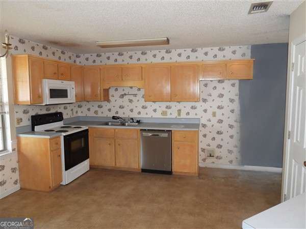 2324 Suttle Ct, Hinesville, GA 31313 - kitchen featuring dishwasher, white microwave, range with electric stovetop, wallpapered walls, and light countertops