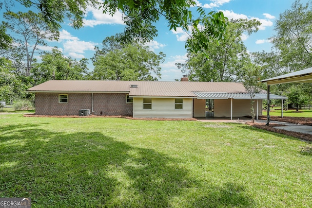 4124 W Rd, Blackshear, GA 31516 - rear view of house with a lawn, central AC unit, metal roof, and a chimney
