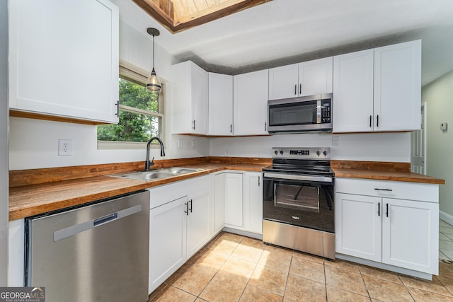 4124 W Rd, Blackshear, GA 31516 - kitchen with appliances with stainless steel finishes, a sink, butcher block counters, white cabinetry, and decorative light fixtures
