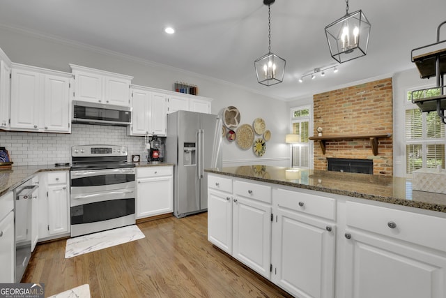 305 River Glen Dr, Roswell, GA 30075 - kitchen featuring stainless steel appliances, a chandelier, ornamental molding, and white cabinets