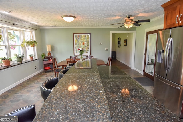 2048 Swint Rd, Griffin, GA 30224 - kitchen with stainless steel fridge, a ceiling fan, brown cabinets, baseboards, and crown molding
