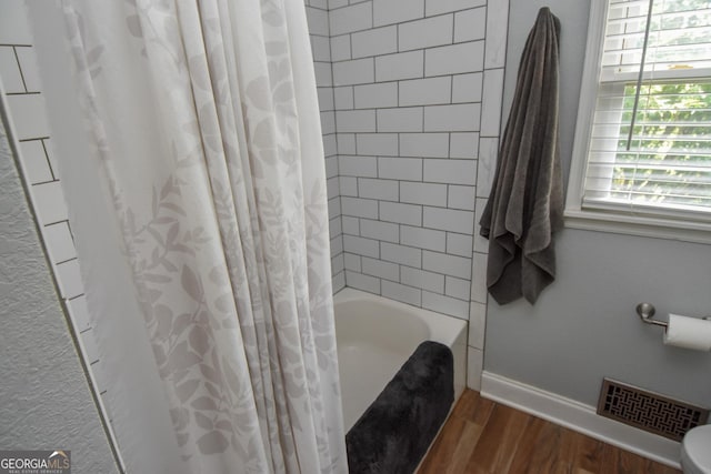 2048 Swint Rd, Griffin, GA 30224 - bathroom featuring wood finished floors, shower / bath combo with shower curtain, baseboards, and toilet