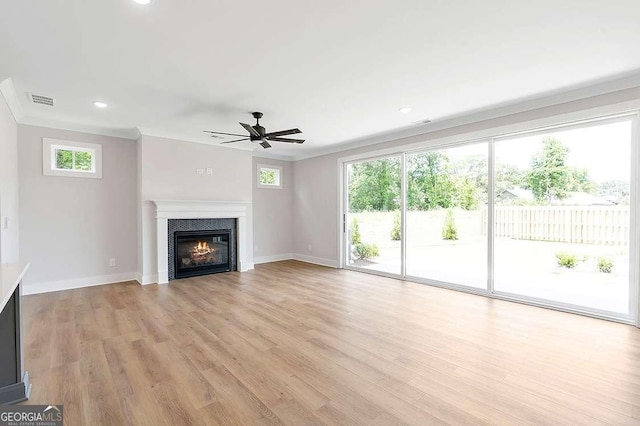 206 Grady Burrell Dr, Holly Springs, GA 30115 - unfurnished living room featuring a ceiling fan, a glass covered fireplace, plenty of natural light, light wood-style flooring, and crown molding
