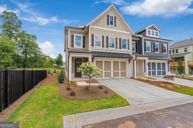 206 Grady Burrell Dr, Holly Springs, GA 30115 - view of front of home featuring board and batten siding, an attached garage, a standing seam roof, driveway, and metal roof