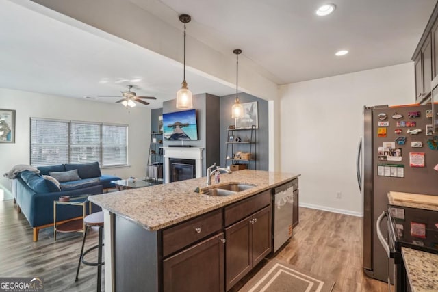 426 Mulberry Row SE, Atlanta, GA 30354 - kitchen featuring appliances with stainless steel finishes, a glass covered fireplace, wood finished floors, dark brown cabinets, and recessed lighting